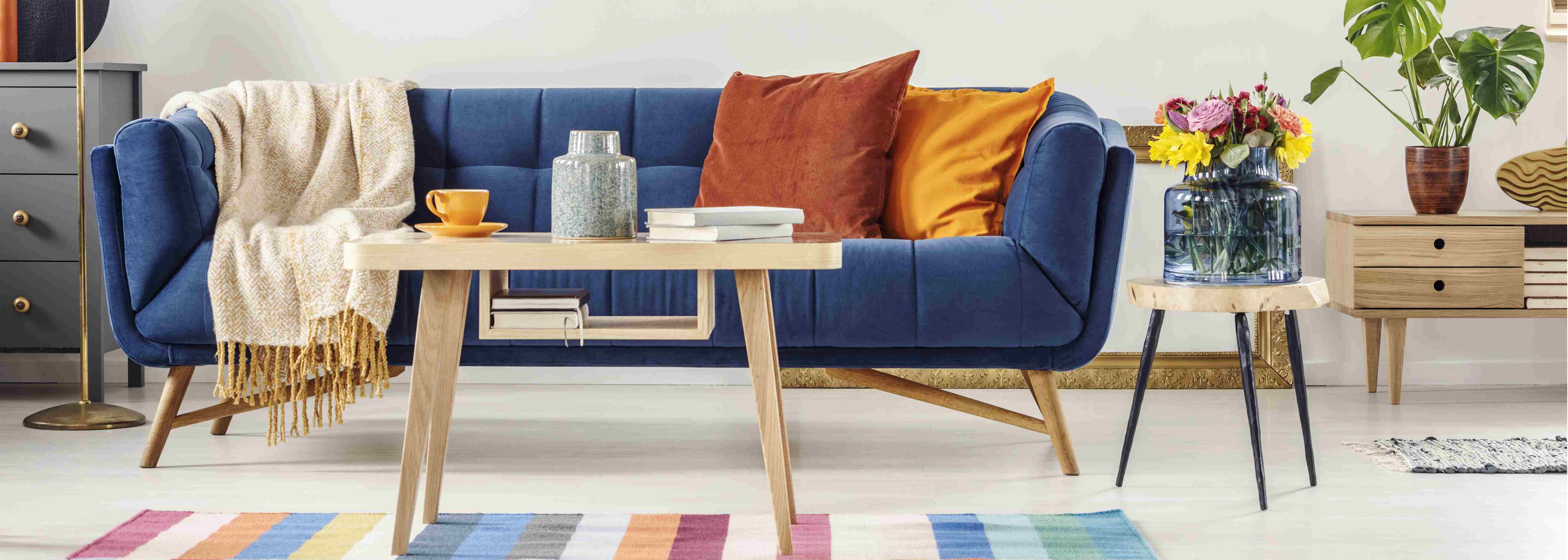 photodune-22330126-closeup-of-a-wooden-table-and-a-blue-settee-with-orange-pillows-l